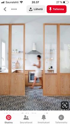 a person walking through a kitchen with wooden doors