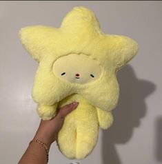 a hand holding a yellow stuffed animal star