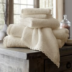 a stack of white towels sitting on top of a wooden table