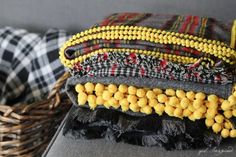 several woven bracelets sitting on top of a table next to a basket filled with beads