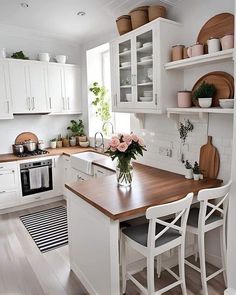 a kitchen with white cabinets and wooden counter tops