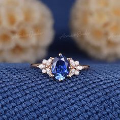 a close up of a ring with a blue and white stone in the center on a blue cloth