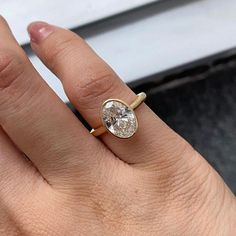 a woman's hand with a ring on it and a diamond in the middle