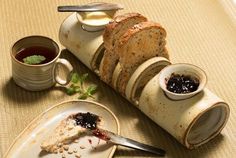 slices of bread and jam on plates with cups