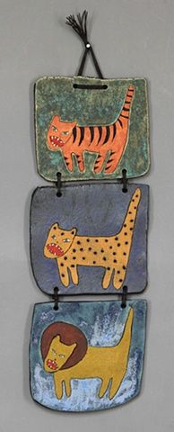 three ceramic wall hangings with animals on them