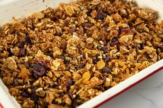 a white dish filled with granola and raisins