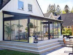 a house with glass walls and patio furniture