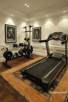 an exercise room with treadmills, machines and pictures on the wall above it