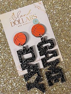 the earrings are made out of black and orange plastic with basketball hoops on them