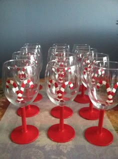 many wine glasses with red and white designs on the rims are lined up in a row