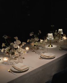 the table is set with white flowers and candles