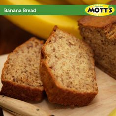 two slices of banana bread sitting on top of a cutting board next to some bananas