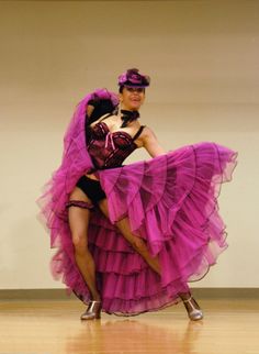 a woman in a purple dress is dancing