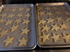 two pans filled with star shaped cookies sitting on top of a stovetop next to each other