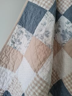 a close up of a quilt on a bed with blue and white checkered fabric