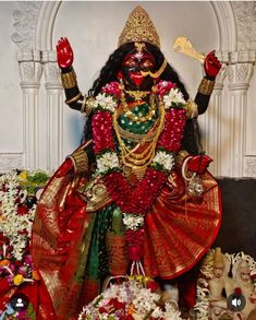 an idol is displayed in front of flowers and other decorations