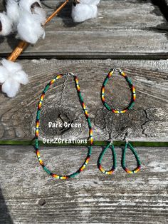 two pairs of beaded scissors sitting on top of a wooden table next to cotton