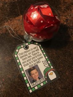 a christmas ornament with a photo on it and a tag attached to it