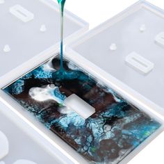 a light switch cover with blue paint pouring out of it to the top and bottom