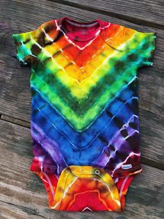 a tie dye bodysuit on a wooden surface