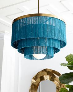 a blue chandelier hanging from the ceiling in a room with a mirror and potted plant