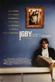 a man sitting on top of a white bench in front of a blue wall with the words igby goes down