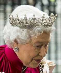 an older woman wearing a tiara and looking at her cell phone