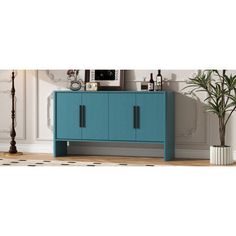 a blue cabinet sitting on top of a wooden floor next to a potted plant