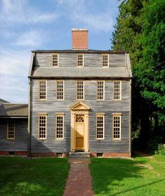 an old house with a brick walkway leading to the front door