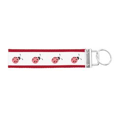 a red and white lanyard with ladybugs on it