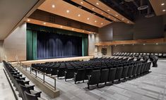 an empty auditorium filled with black chairs