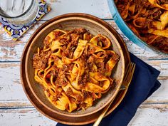 a bowl filled with pasta and meat on top of a table