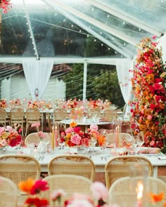 the tables are set with flowers and candles for an elegant wedding reception in a tent