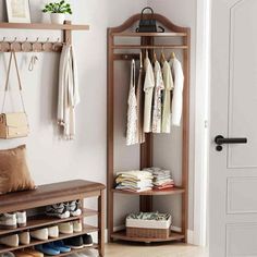 a coat rack with shoes and purses on it in front of a white door