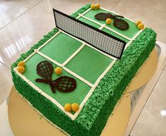 a cake shaped like a tennis court and rackets on top of green frosting