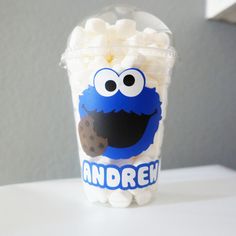 a cup filled with marshmallows sitting on top of a white table next to a wall