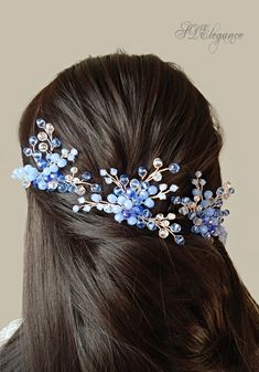 a close up of a woman's head wearing a hair comb with blue flowers on it