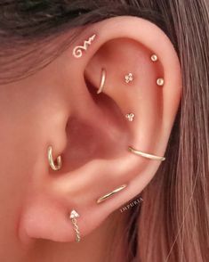 an ear with three different types of piercings on the top and bottom of it