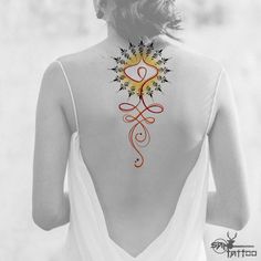 the back of a woman's neck with an intricate tattoo design on her lower back