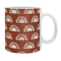 an orange and white coffee mug with sun designs