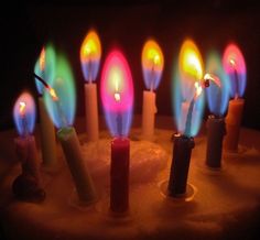 there are many lit candles on the cake that have been turned on with colored lights