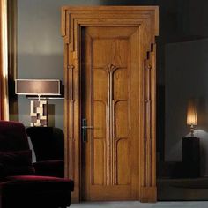 a large wooden door sitting next to a red chair in a living room filled with furniture