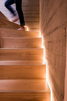 a person walking up some stairs with their foot on the steps and light coming through