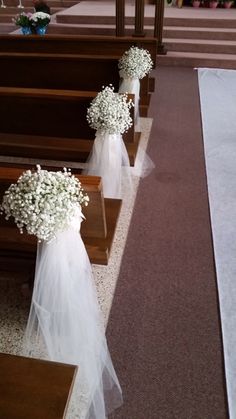 white flowers are placed on the pews of a church