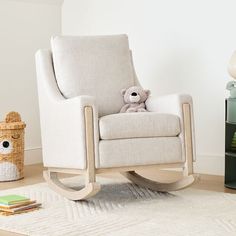 a white rocking chair with a teddy bear on it