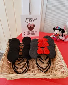 there are many mickey mouse ears on display in the basket at the table with other items