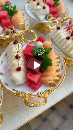 four plates with different types of desserts on them sitting on top of a table