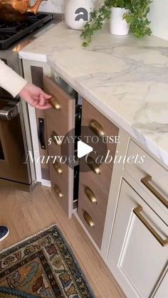 a woman opening the door to a kitchen with marble counter tops and white cupboards