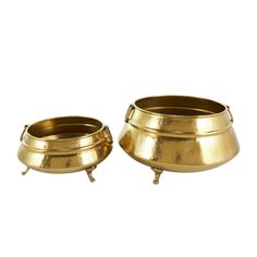 two brass pots sitting next to each other