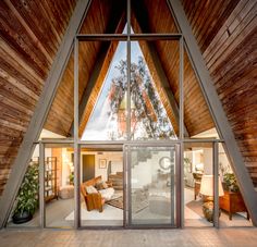 the inside of a house with wood shingles and glass doors that lead to an outside patio